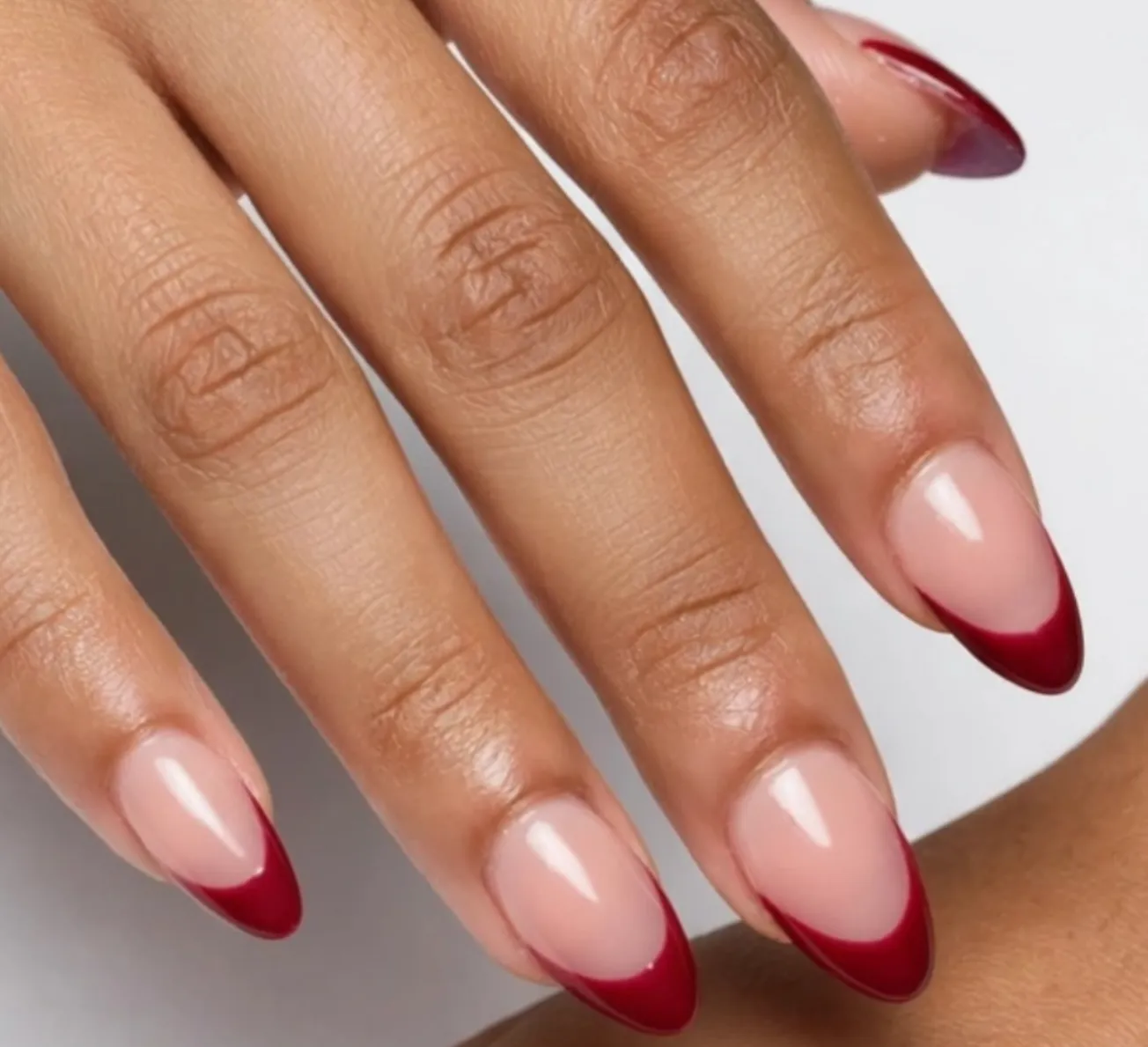 Almond nails with a deep red French tip